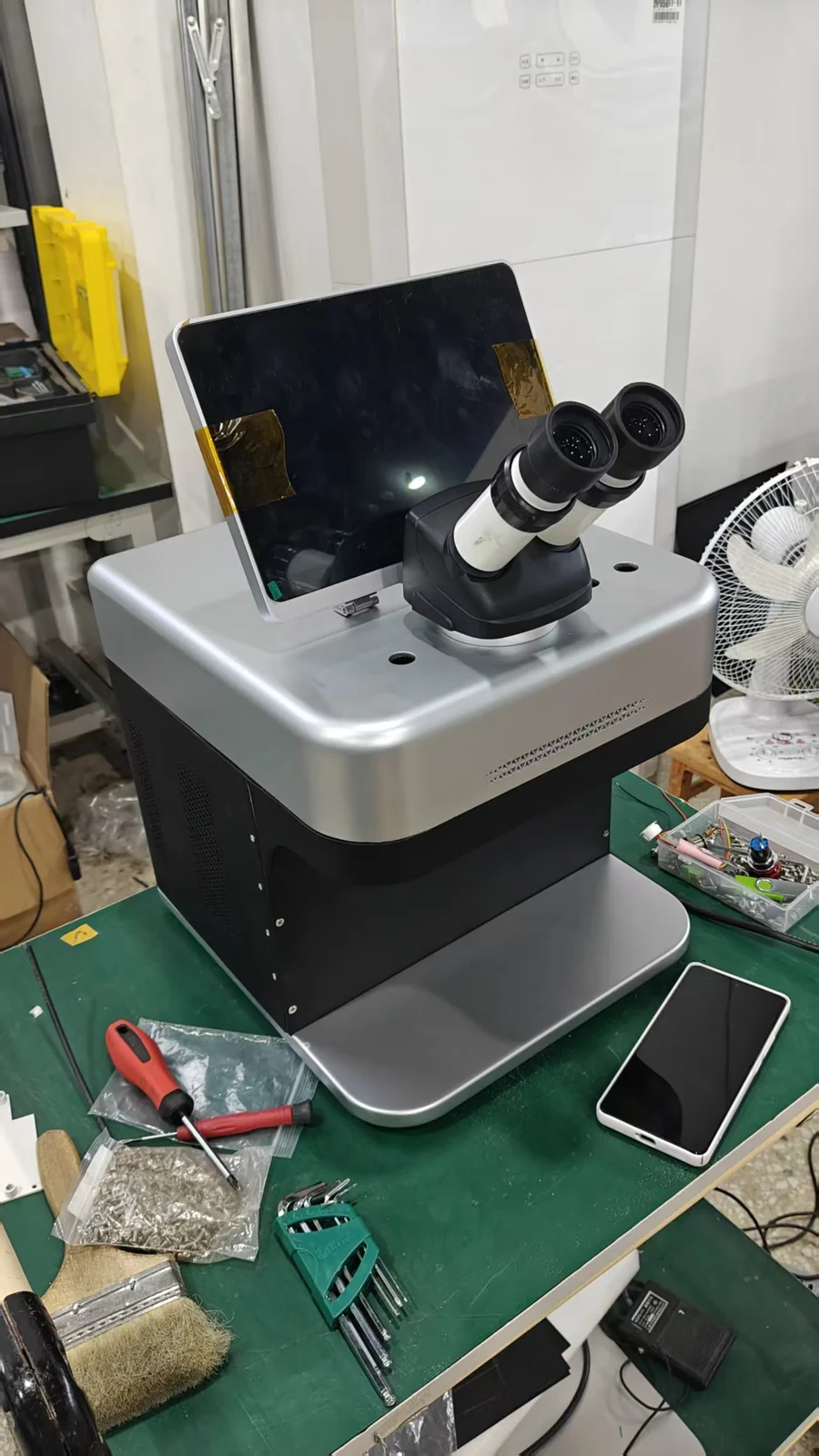 The M3 on a workshop bench with a phone beside it for scale