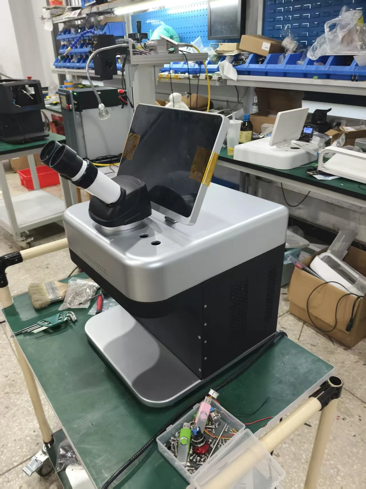 Jewelry laser welder for repair shops: the M3 with its screen lifted toward the customer opposite